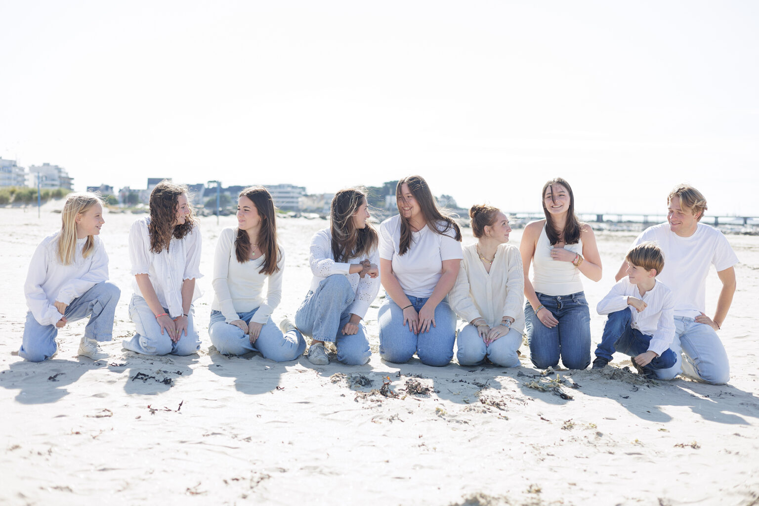 Photo d'une famille de cousins qui rient ensemble sur la plage