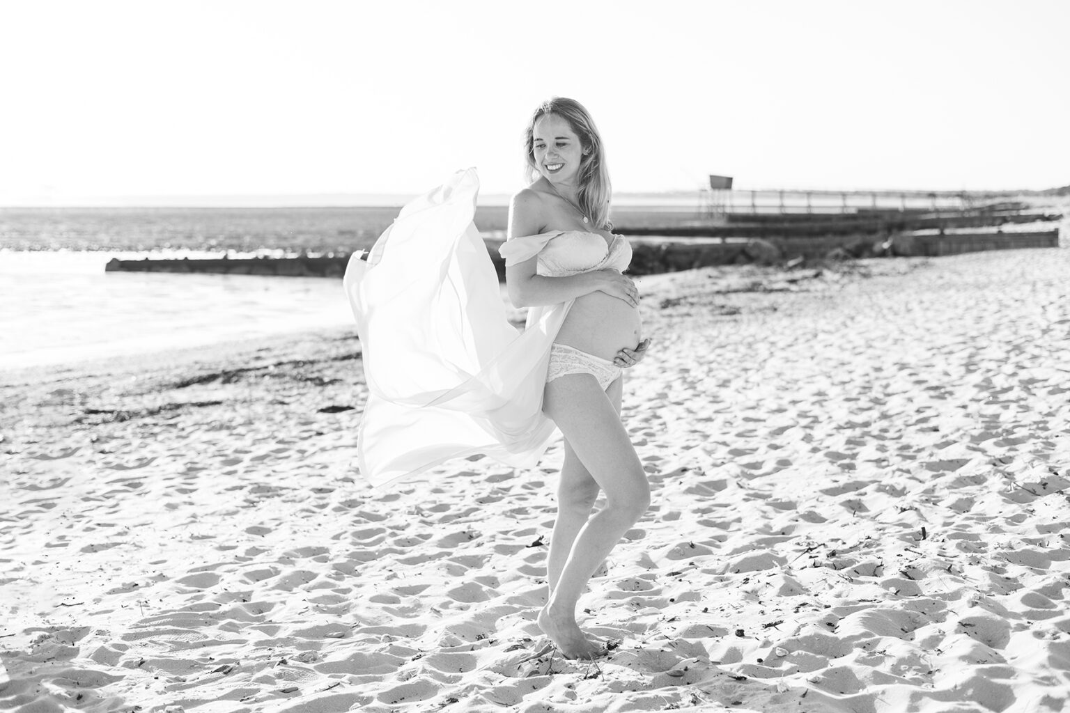 Portrait d'une femme enceinte sur la plage la robe au vent